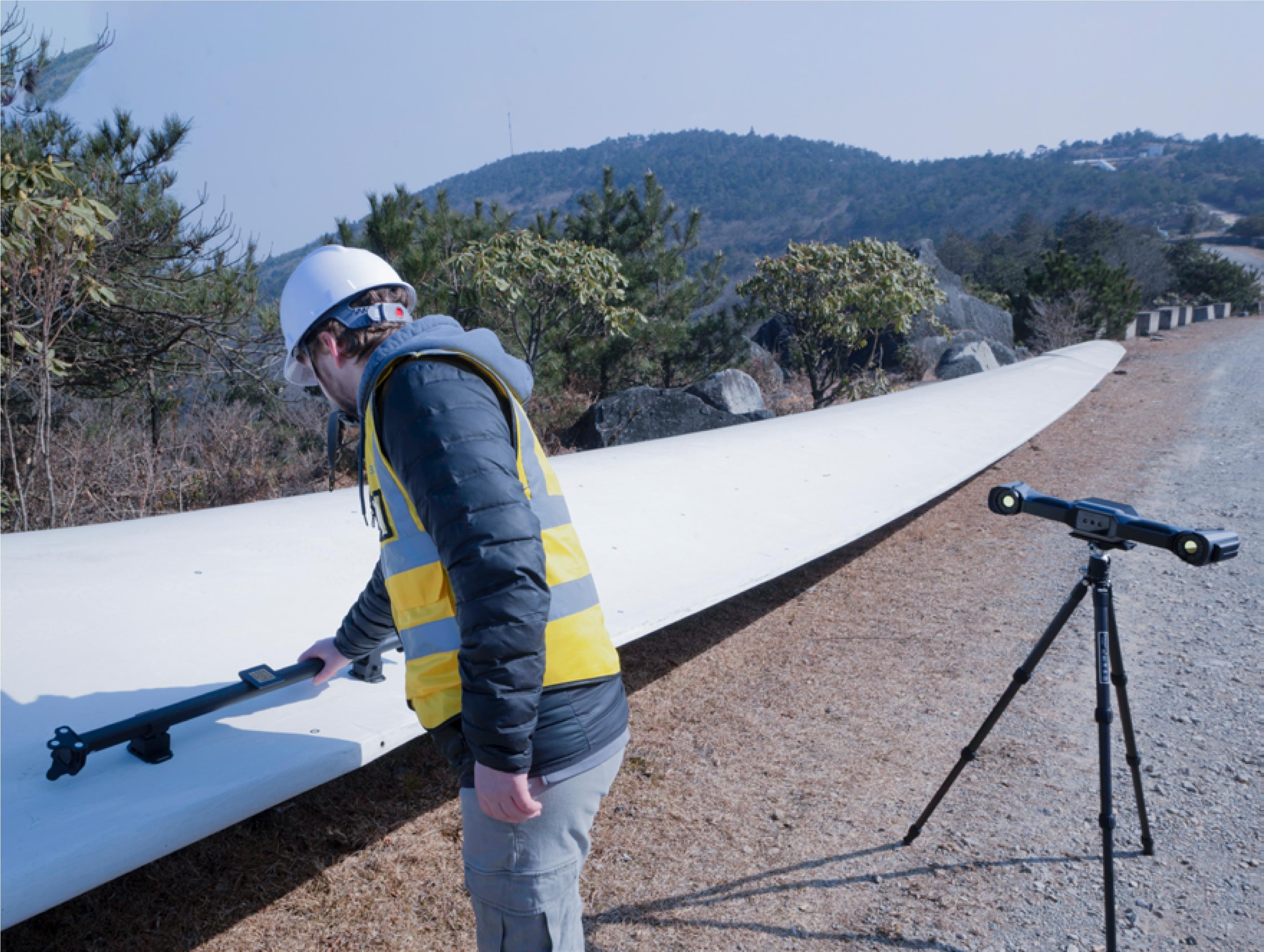 An engineer places a calibration rod on a turbine blade with VPG technology for improving volumetric accuracy
