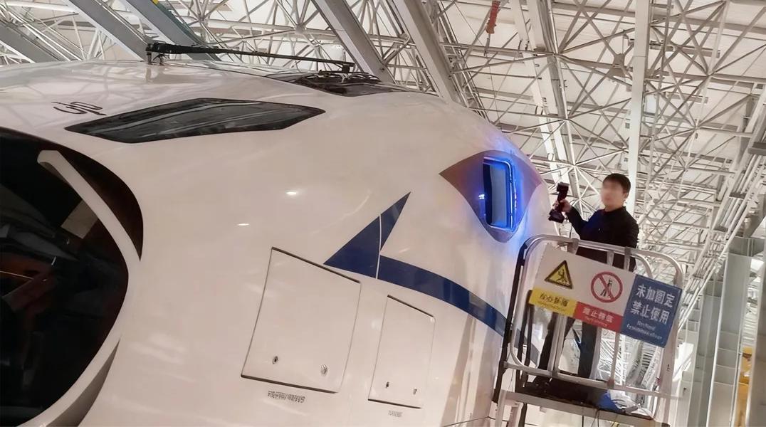 Engineer using FreeScan UE Pro2 to inspect railway train window assembly and analyze deformation in manufacturing process
